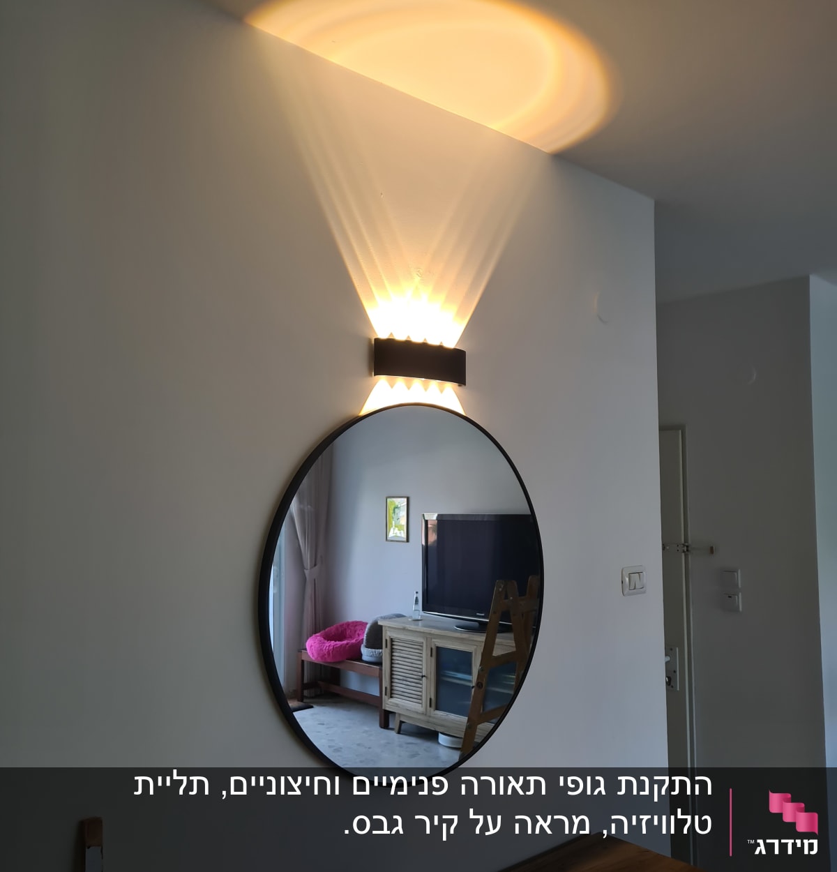 מראה עגולה על קיר עם מנורה מעליה